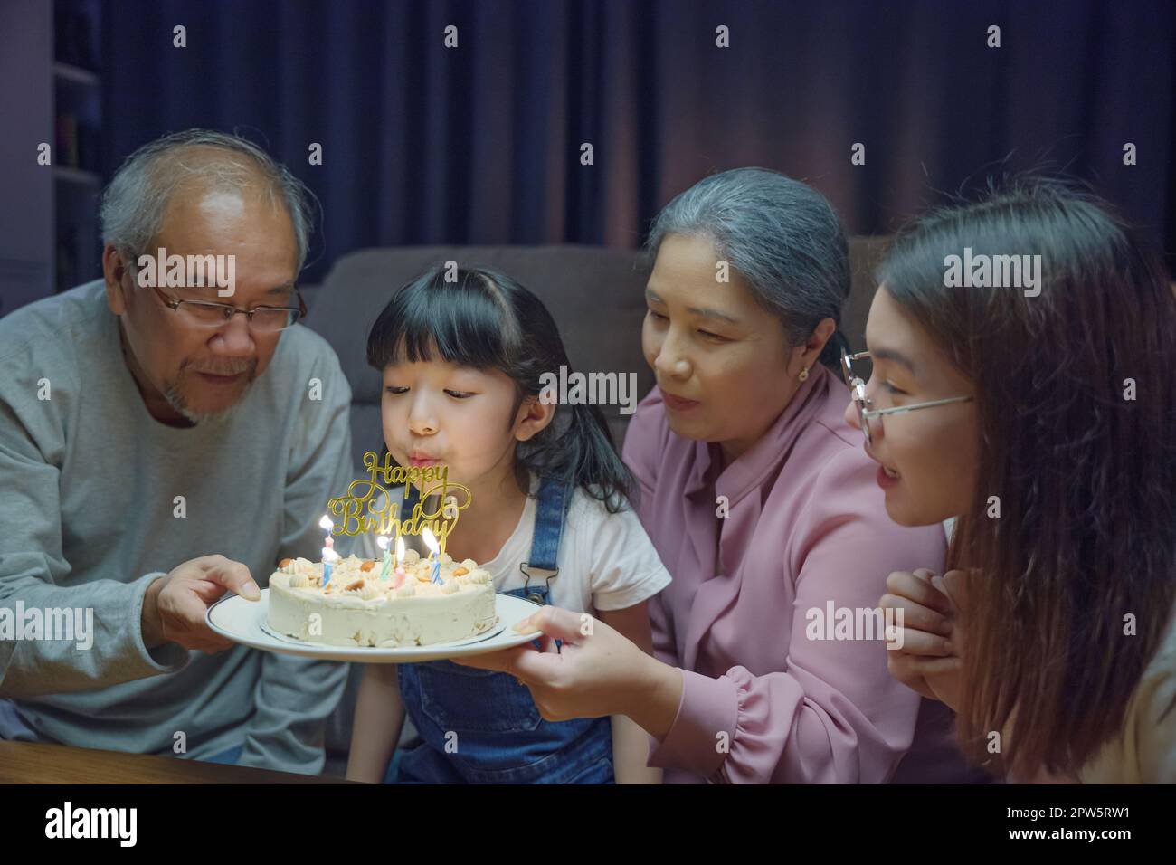 Happy Asian family grandparents and mother celebrating enjoy birthday