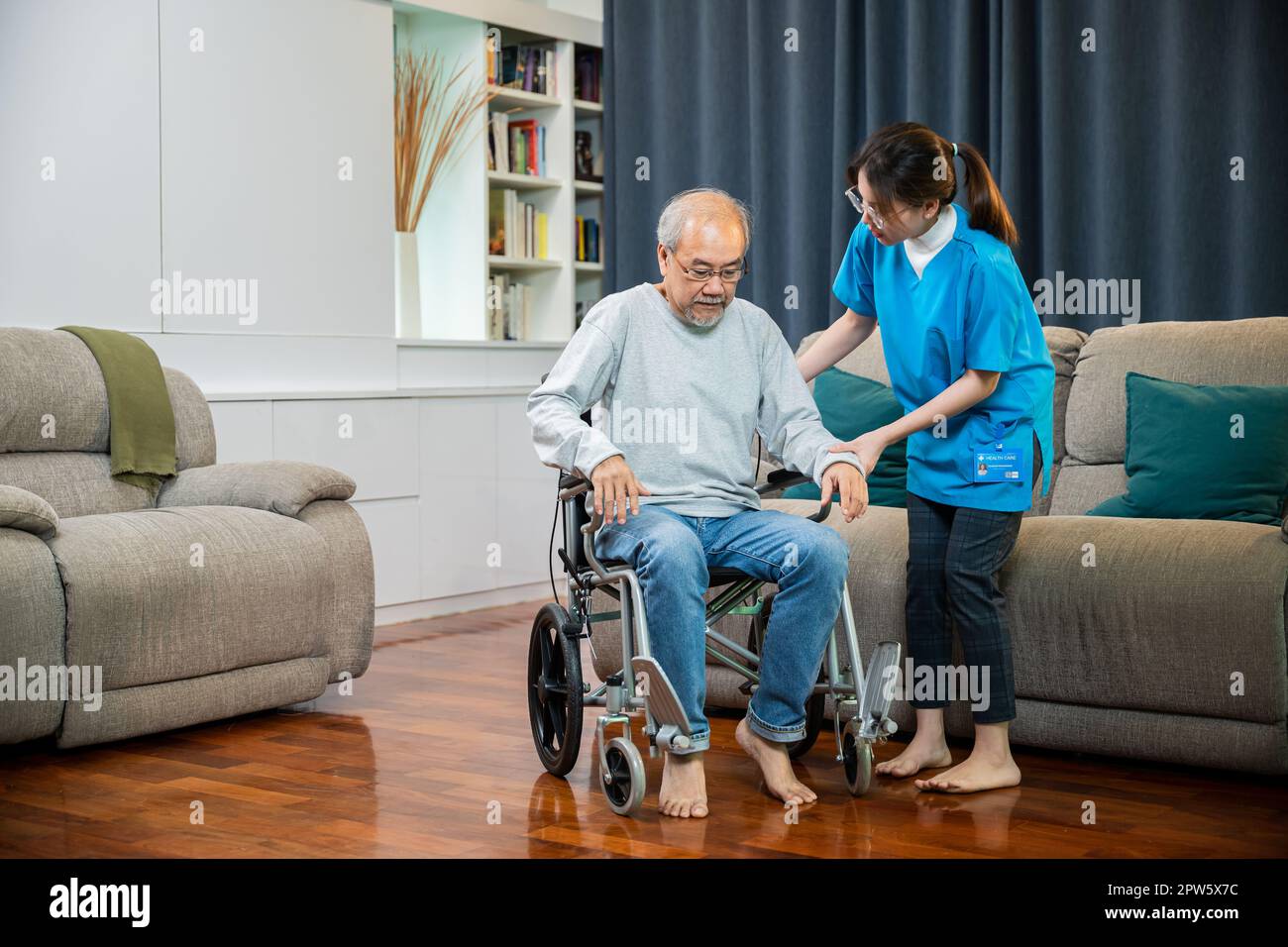 Doctor support old man to getting up to exercise, help handicapped elderly stand up, Asian woman