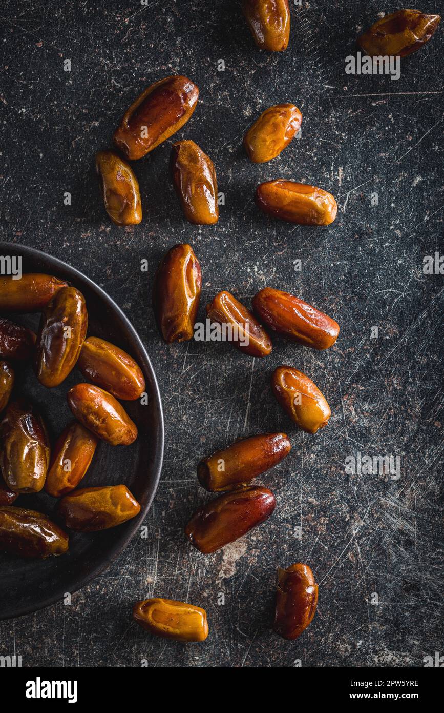 Dried dates fruit on the black table. Top view Stock Photo - Alamy