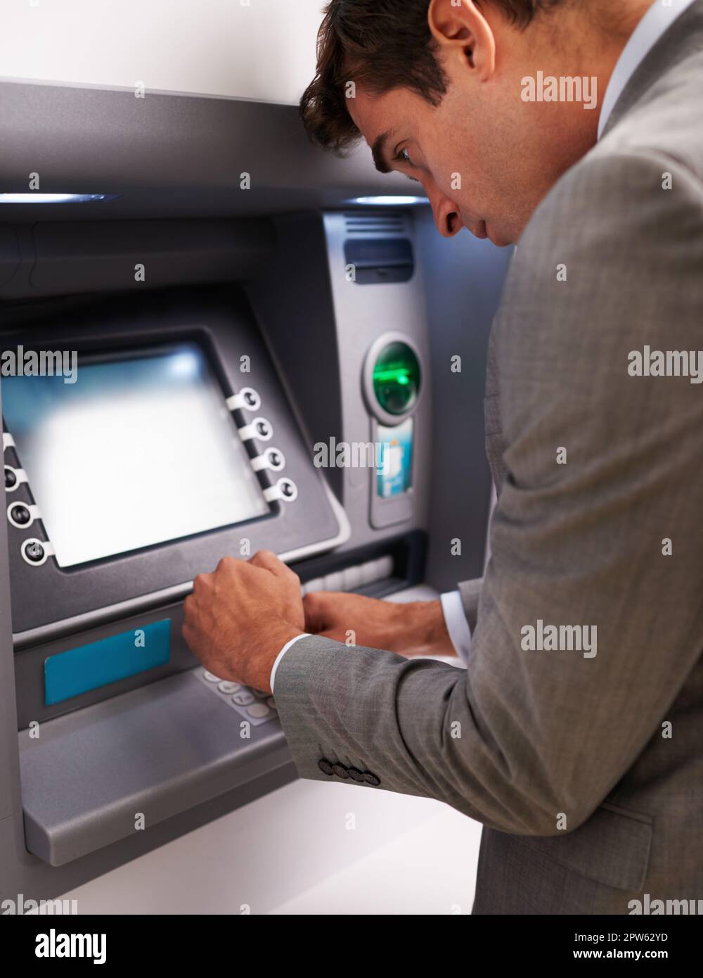 Grabbing some cash. a businessman making a cash withdrawal at an ATM