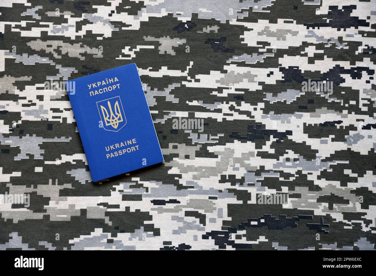 Ukrainian foreign passport on fabric with texture of military pixeled
