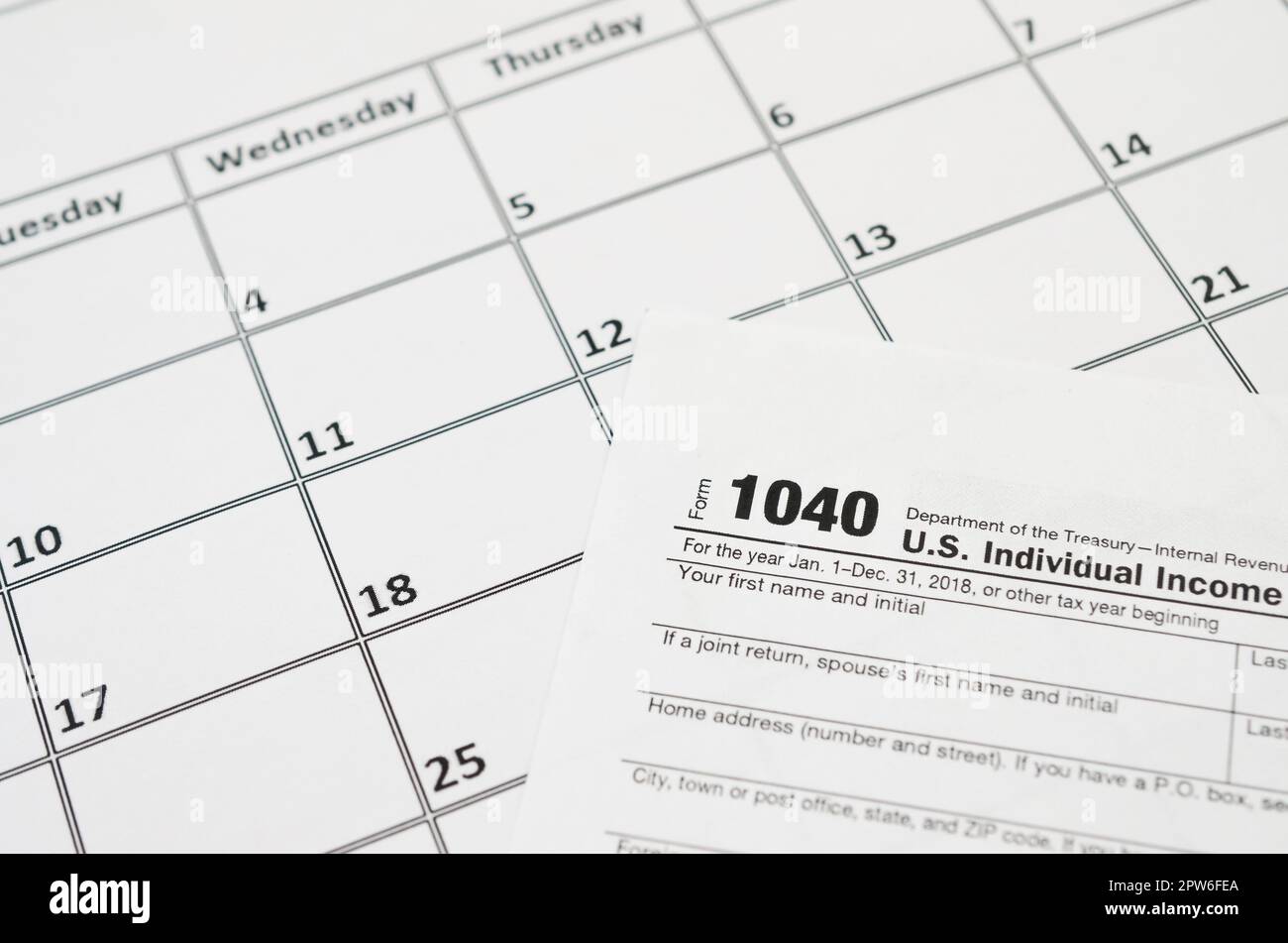 IRS Form 1040 Individual Tax Return blank lies on empty calendar