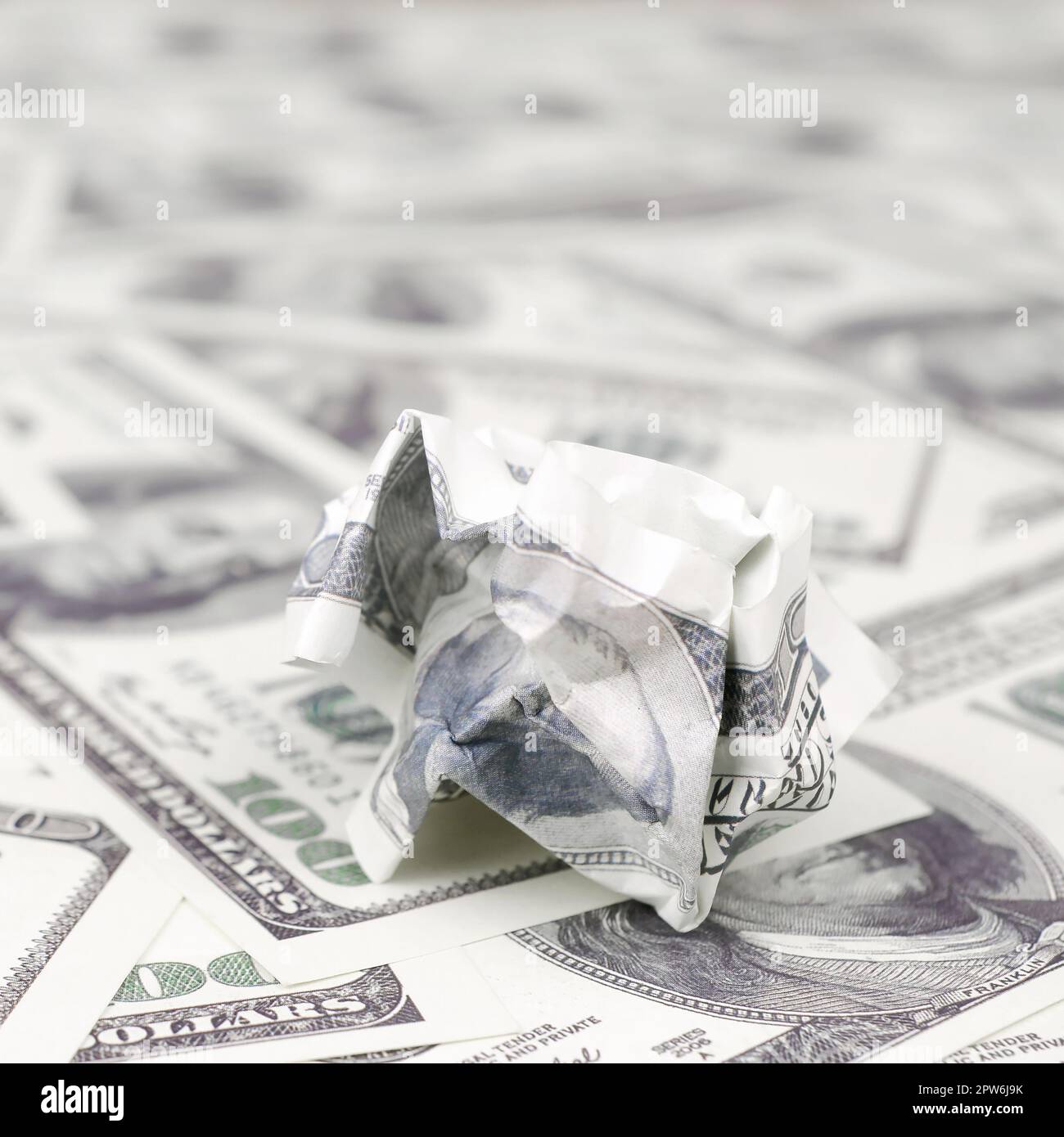 Crumpled dollar bill of the United States lies on the set of smooth money bills. Concept of unreasonable waste of money Stock Photo