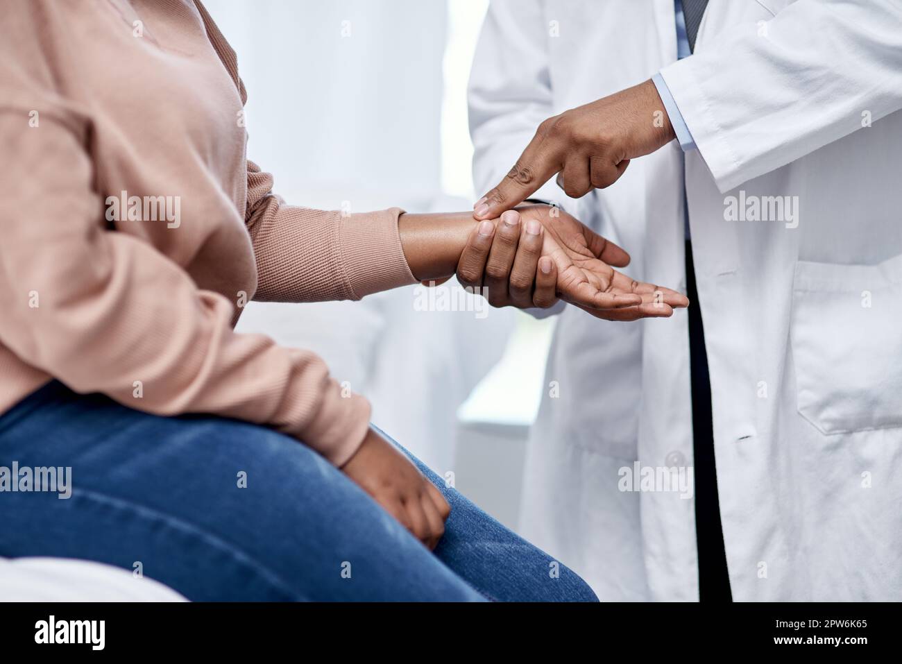 Doctor checking wrist pulse, heart rate and vitals of a sick patient