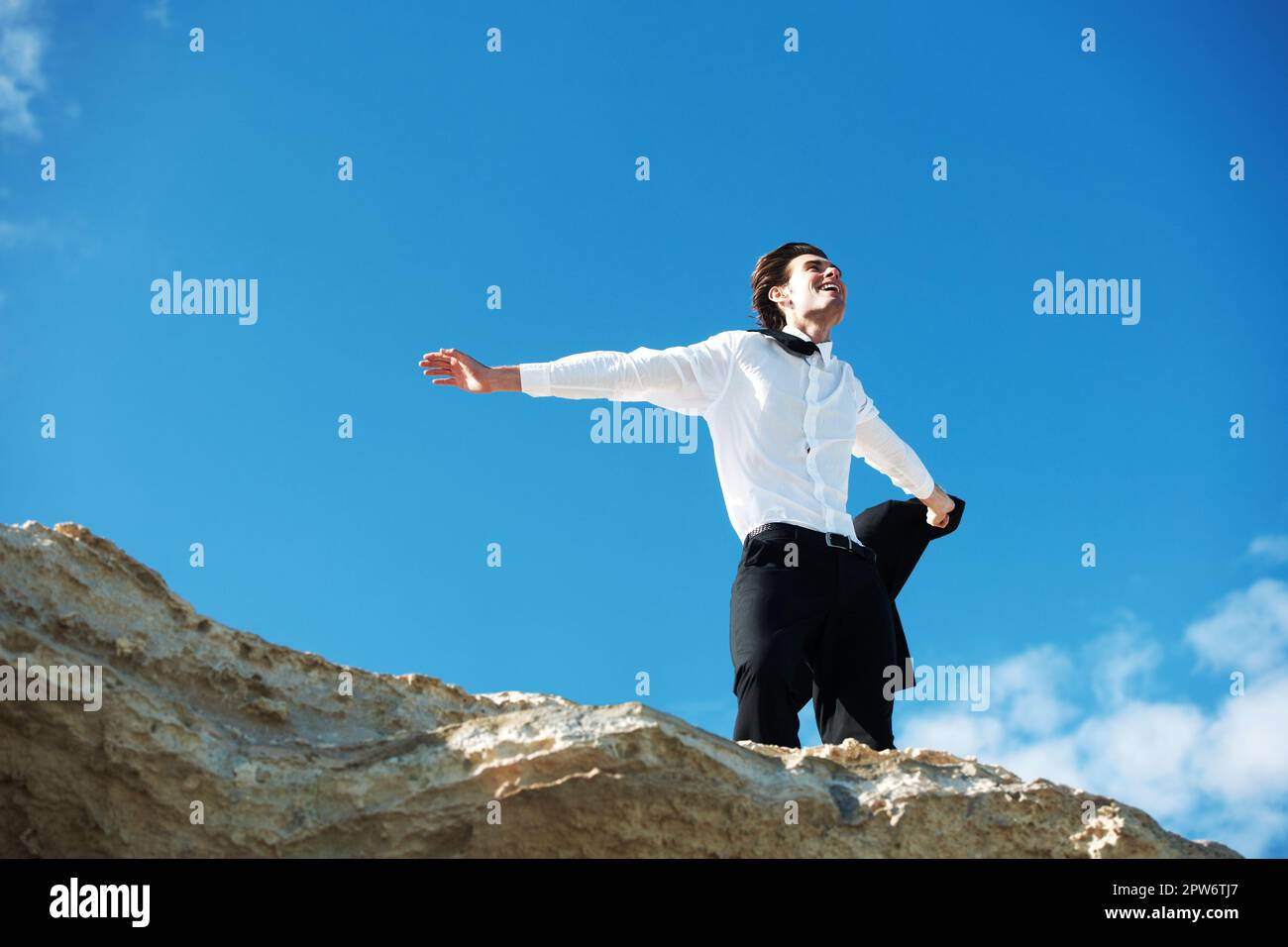 Revelling in the winds of change. Low-angle view of happy businessman ...