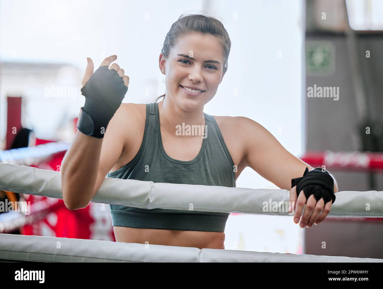 Active, fit and young female boxer ready for a boxing exercise, workout and training at a gym. Athletic, happy and sporty woman enjoying fitness and e Stock Photo