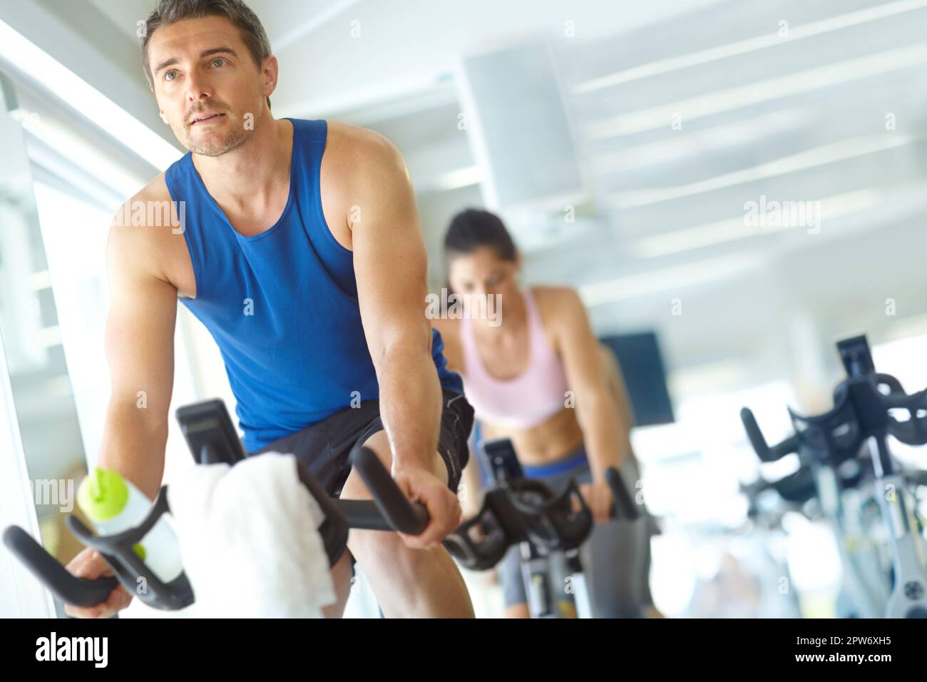 Spinning their way to toned bodies. A man and woman exercising in