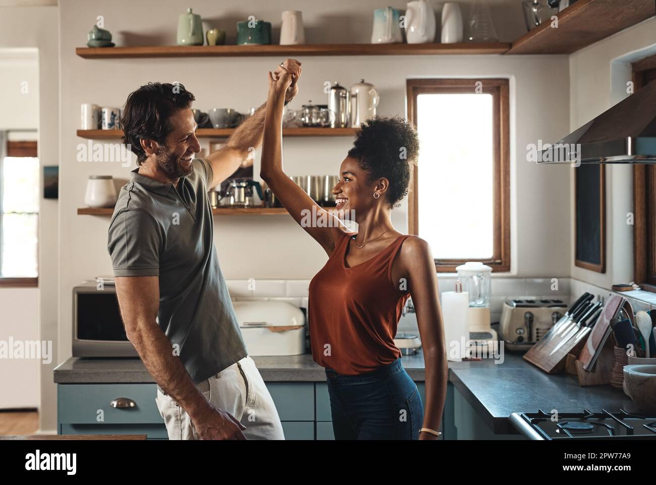 Happy, in love and dancing while an interracial couple have fun and  enjoying time together in home kitchen. Husband and wife sharing a dance  while bei Stock Photo - Alamy