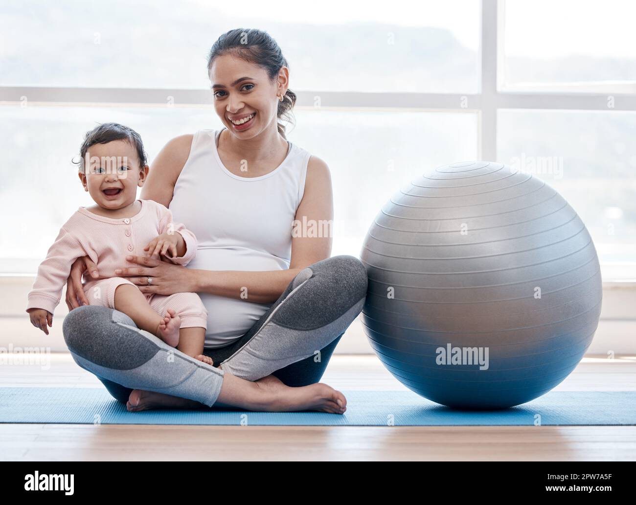 Little cute baby girl doing yoga exercise on the grass at