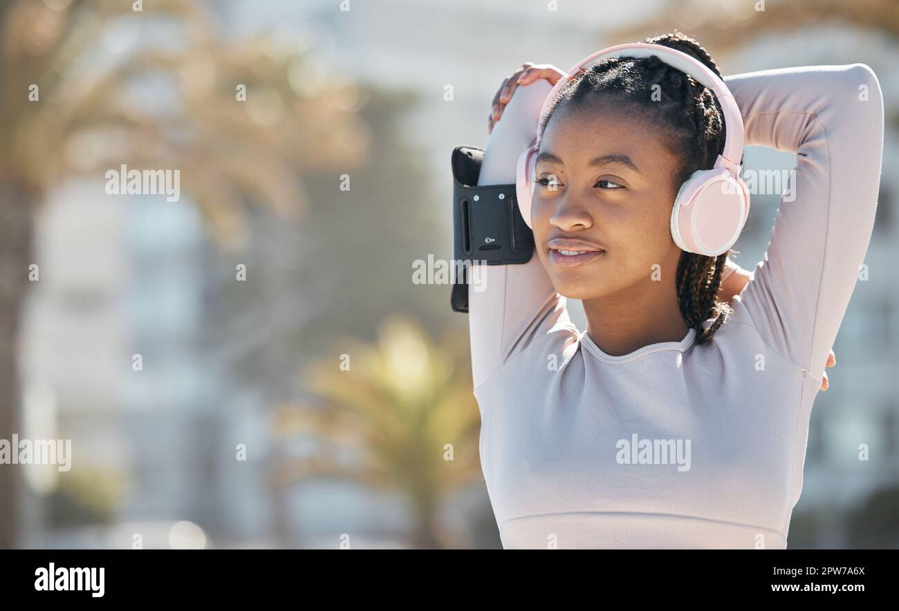 Black woman, exercise and fitness stretching outdoor and listening to music in nature for energy and cardio workout for health and wellness. Athlete r Stock Photo