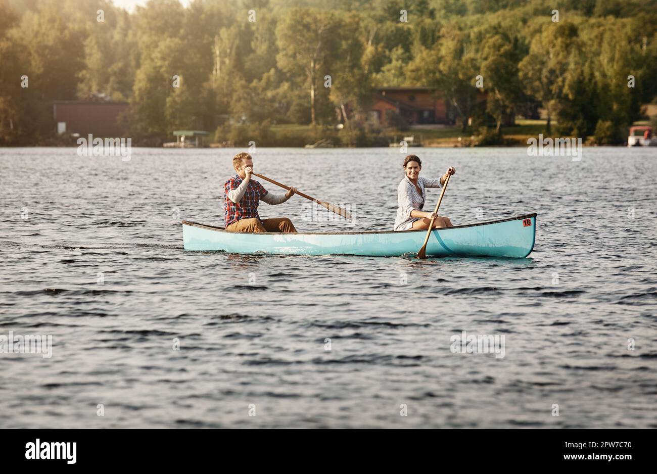 Find your rhythm and row. Portrait of a young couple going for a canoe ...