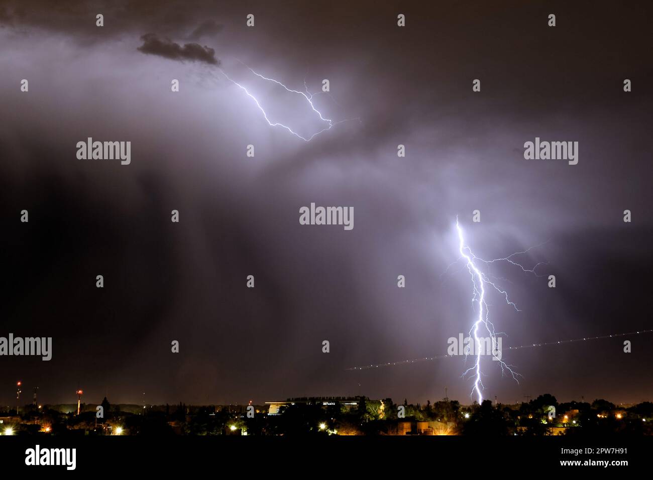 Lightning strikes at night during a severe thunderstorm over the city ...