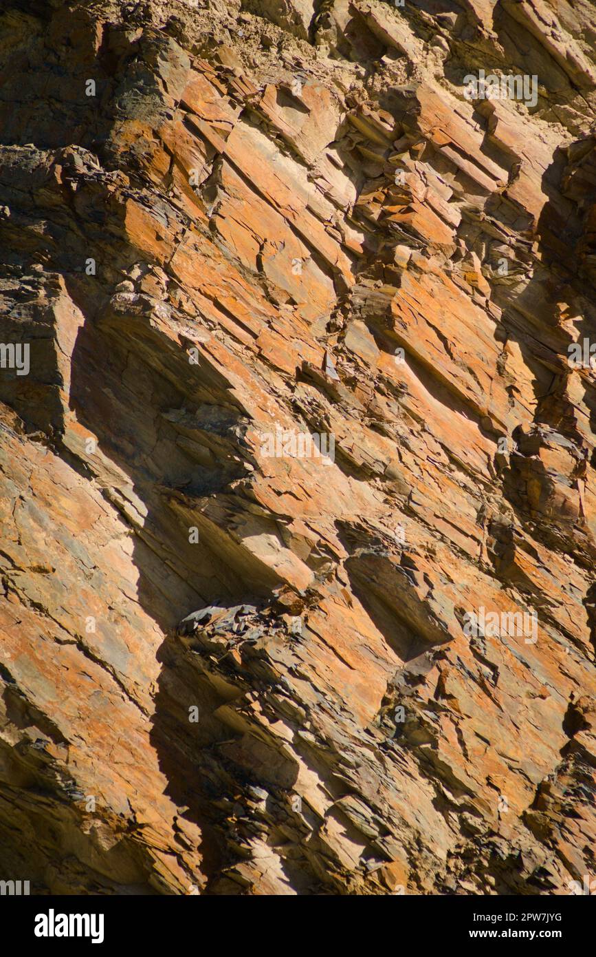 Reddish layered rock wall, with visible geological strata in the Andes ...