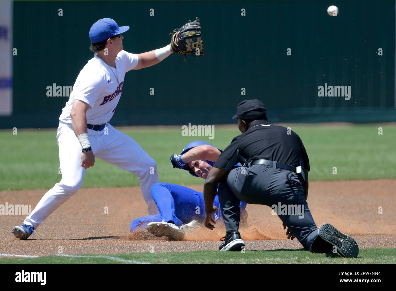 Texas A&M Corpus Christi runner Max Puls (25) is safe on a return to the  bag as Houston Christian first baseman Logan Letney (10) gets the throw to  late during an NCAA