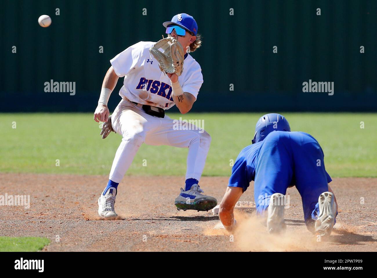 Texas A&M Corpus Christi runner Max Puls (25) is safe on a return to the  bag as Houston Christian first baseman Logan Letney (10) gets the throw to  late during an NCAA