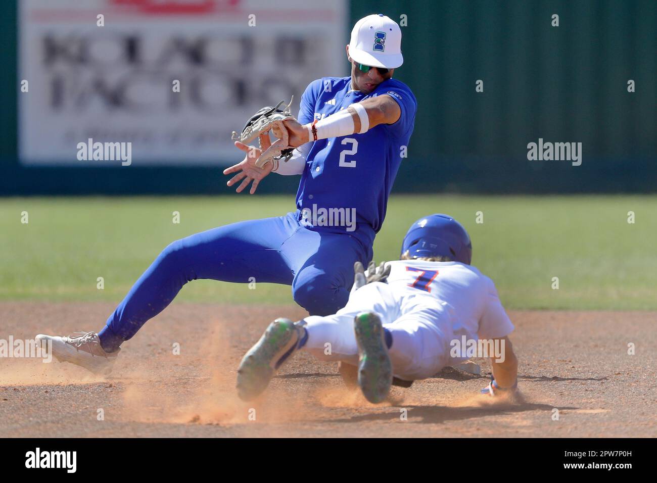 Texas A&M Corpus Christi runner Max Puls (25) is safe on a return to the  bag as Houston Christian first baseman Logan Letney (10) gets the throw to  late during an NCAA