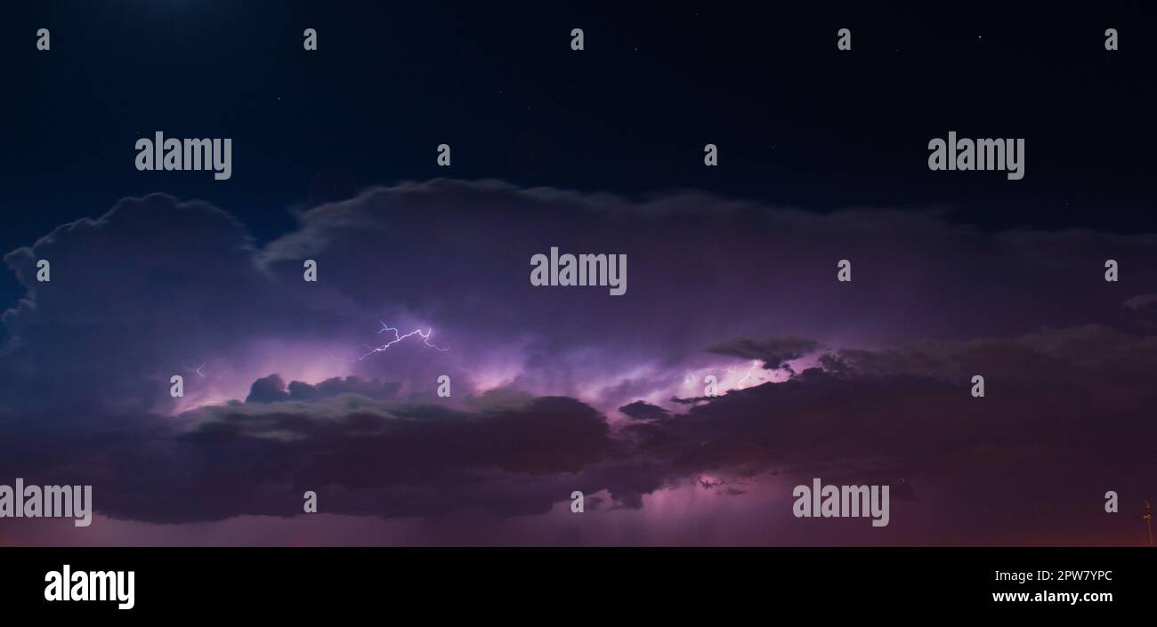 Lightnings in heavy, purple storm clouds at night Stock Photo - Alamy