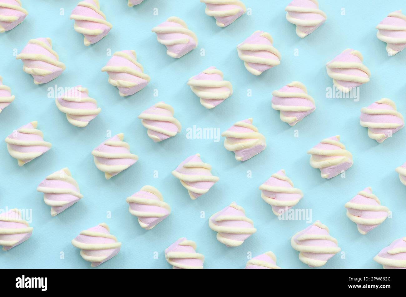 Colorful marshmallow laid out on blue paper background. pastel creative textured pattern. minimal. Stock Photo