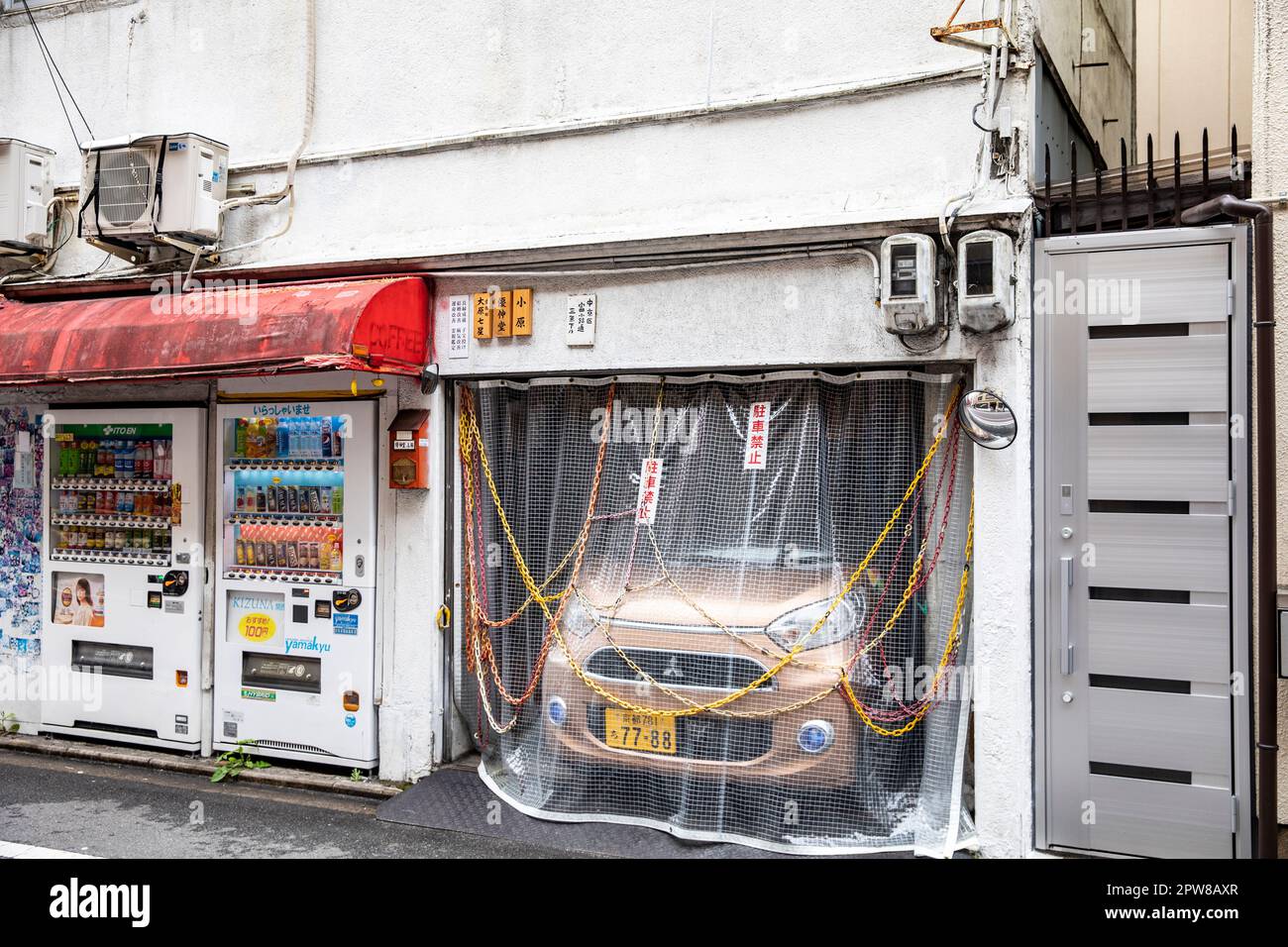 Kyoto Japan, small Japanese car squeezed into a tiny garage with chains