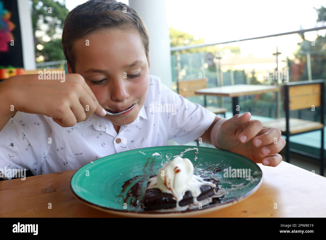 Boy eating Brownie dessert with ice cream in restaurant Stock Photo Alamy