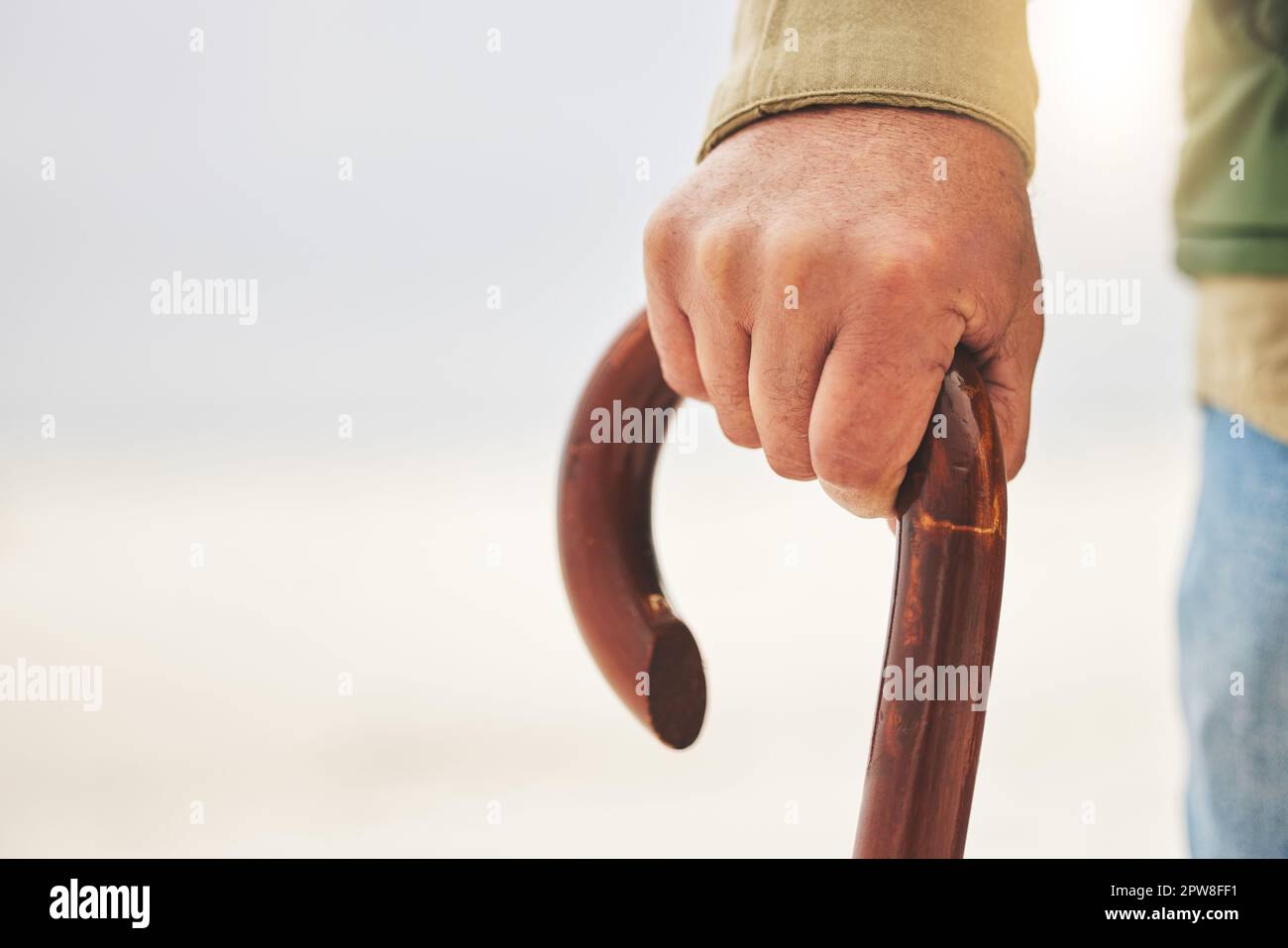 Hand, senior man with disability and cane or walking stick for support