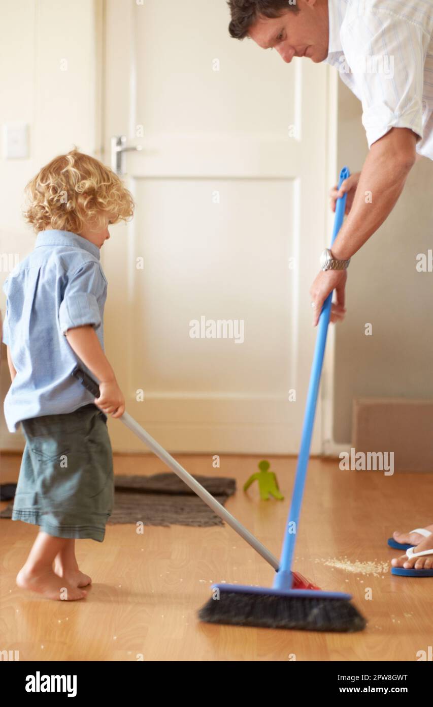 Father with boy kid sweep up mess, family cleaning together and help with broom and dustpan