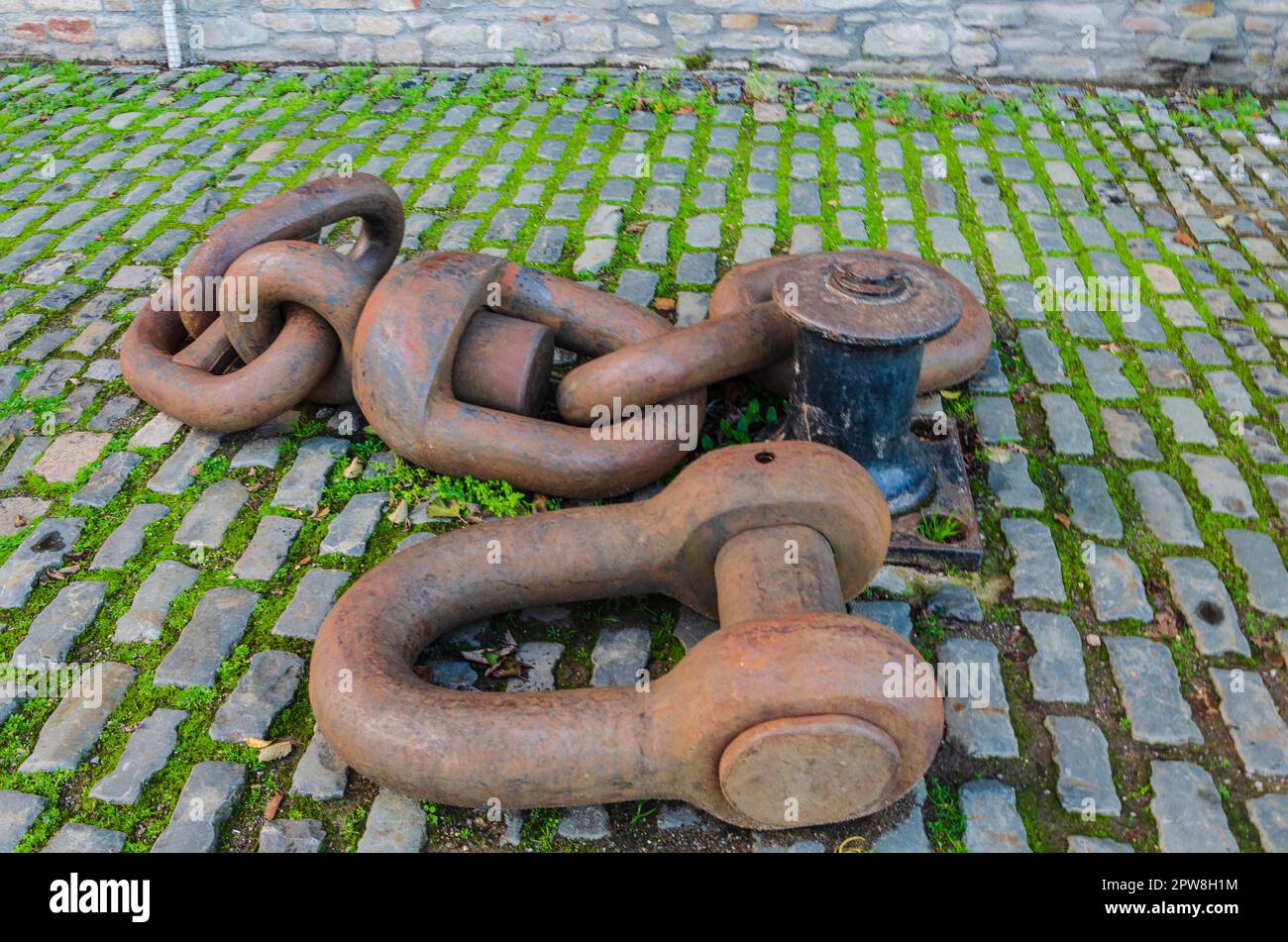 Bristol South west England November 25 2022 - Large rusty mooring chain lying on cobblestones probably from an old sailing ship on Bristol's quayside Stock Photo