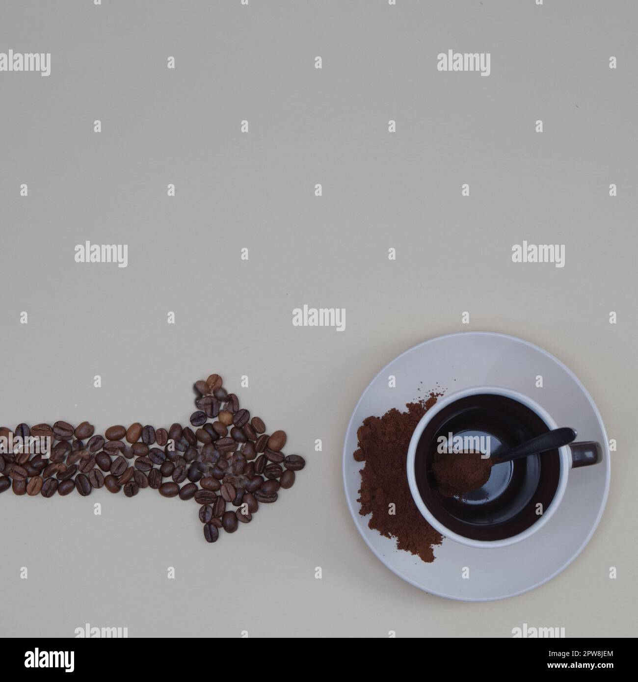 Coffee cup, spoon, and coffee bean arrow with copy space on beige ...