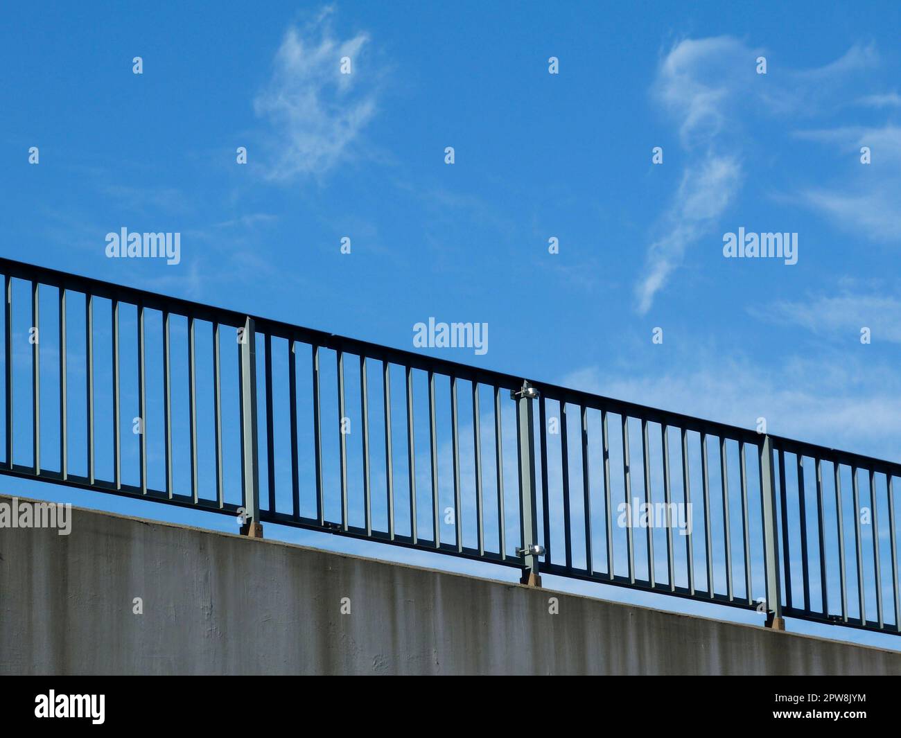 steel guard rail with vertical pickets and posts along highway. blue
