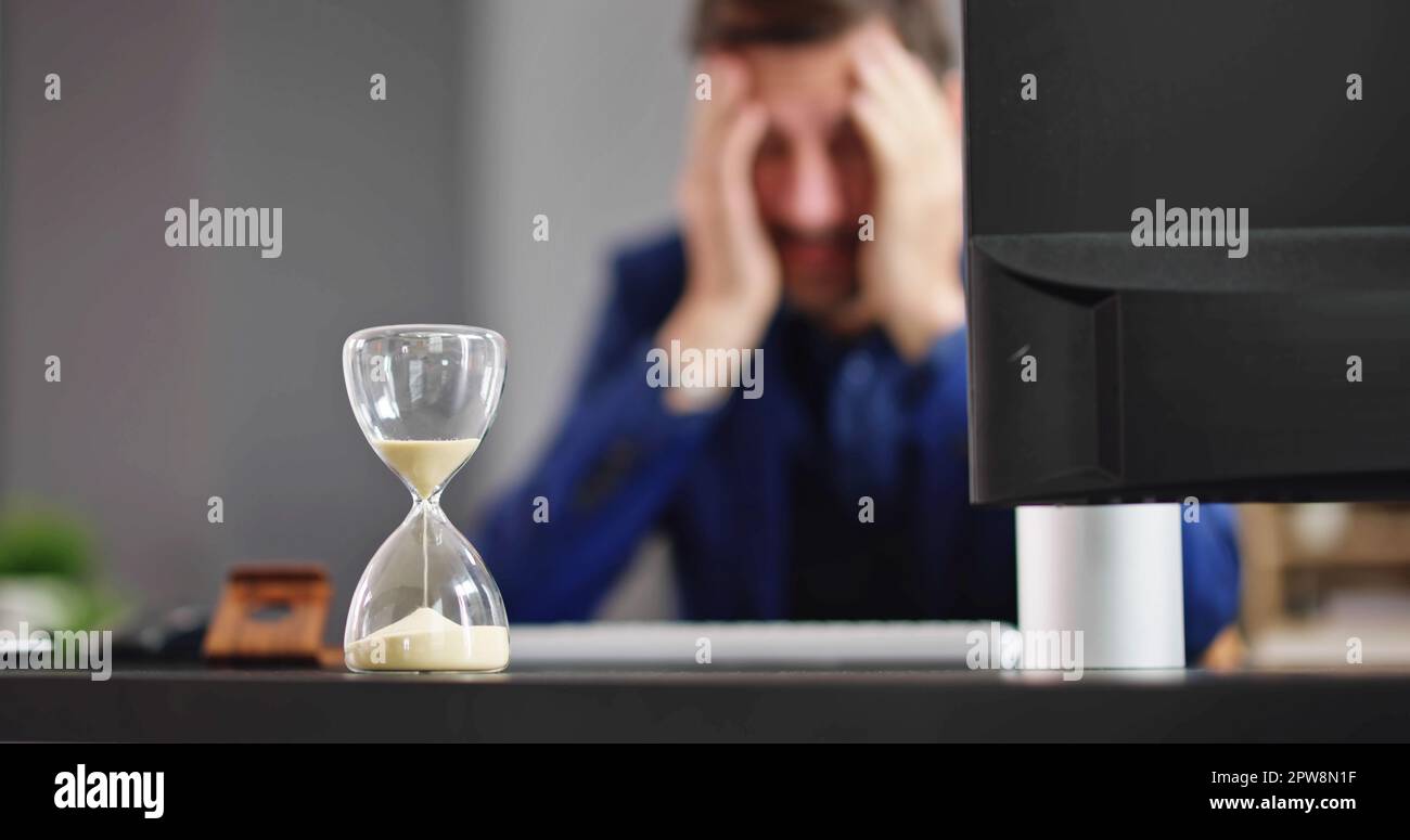 Late Invoice And Billing Deadline With Hourglass At Desk Stock Photo