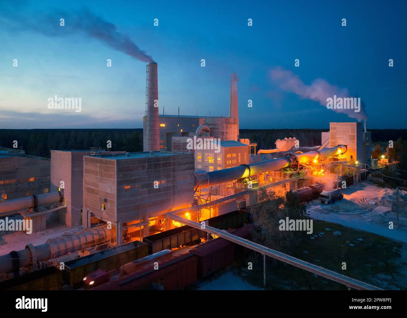 Cement factory with illuminated yard and floating steam Stock Photo - Alamy