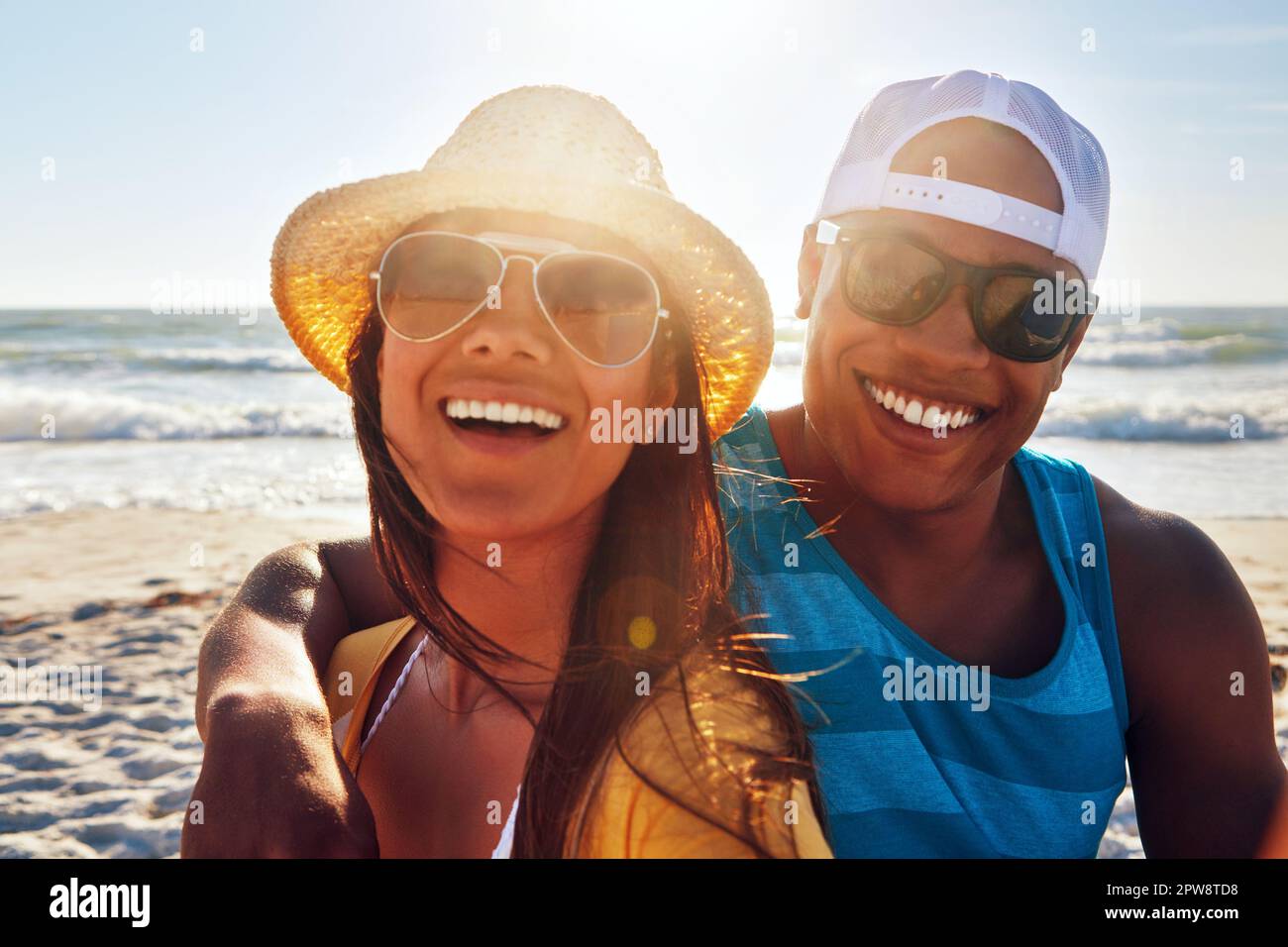 Im lucky to be in love with my best friend. Portrait of a young couple sitting on the beach on a sunny day. Stock Photo