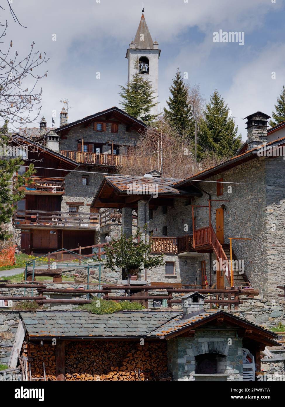 Traditional and quaint stone built houses with a wood stack in the foreground in the alpine town of Lignan in the Aosta Vally, NW Italy Stock Photo