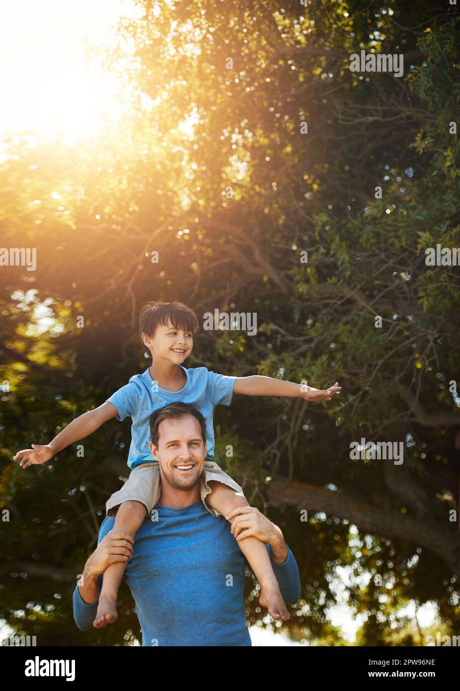 Riding high on dads shoulders. Portrait of a father and his young son spending quality time together outside. Stock Photo