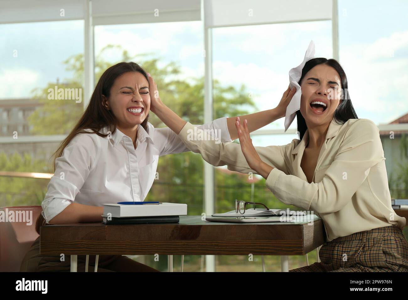 Office Infighting Colleagues fighting at table in office. Workplace conflict Stock Photo ...