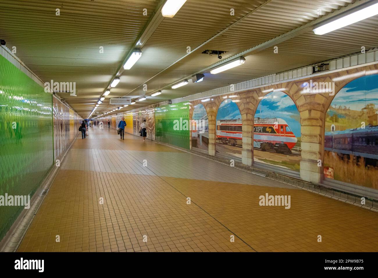 Weekend travelers walk past the murals and through the tiled Devonshire Street Tunnel at Sydney's Central Station in New South Wales, Australia Stock Photo