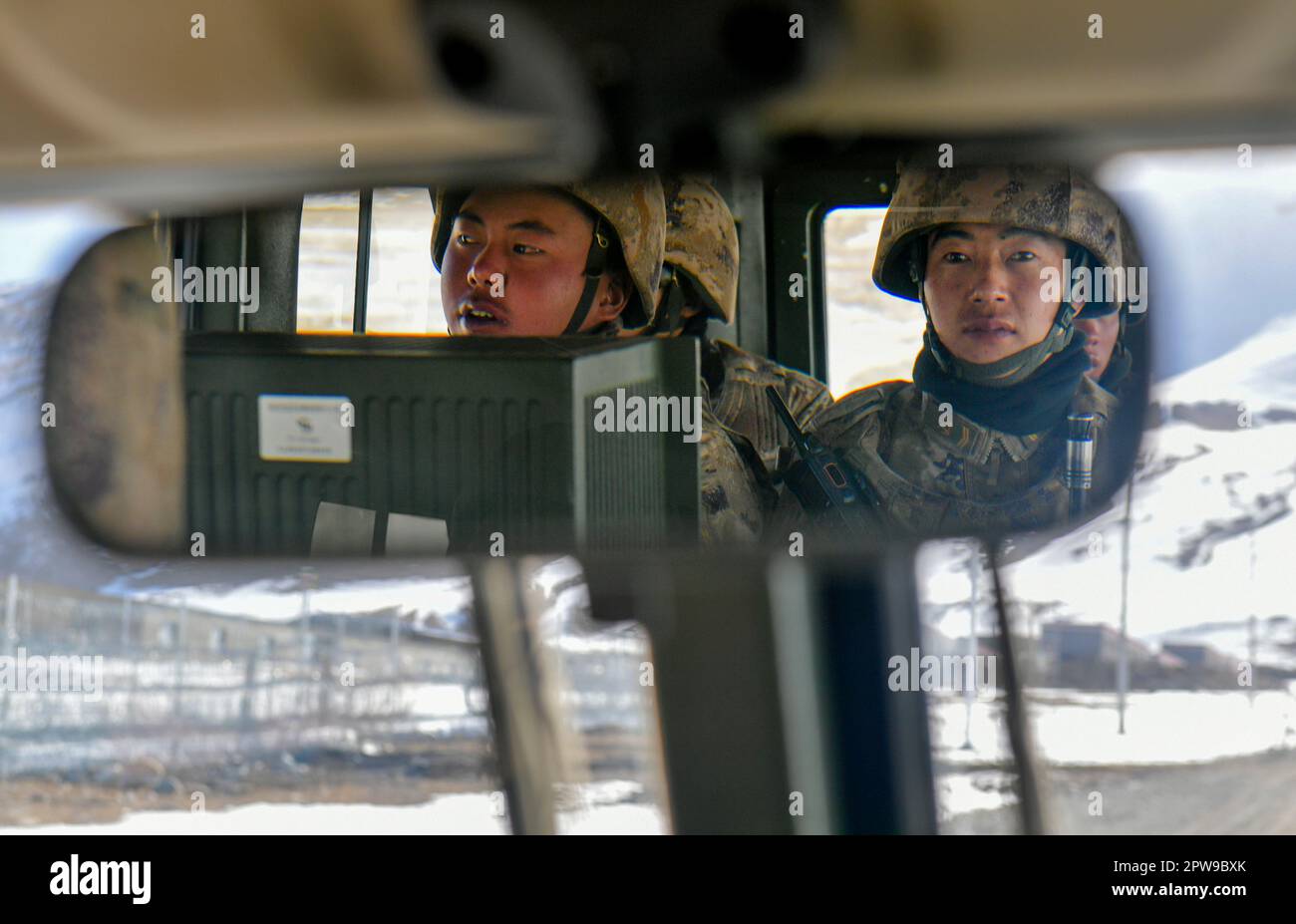 (230429) -- KHUNJERAB, April 29, 2023 (Xinhua) -- Zhou Linping (R) patrols in a car with other soldiers in Khunjerab, northwest China's Xinjiang Uygur Autonomous Region, April 14, 2023. Gao Guanghui, a recruit who had just joined the army for 7 months, was shocked when he walked into the honor room of the border defense regiment in Khunjerab, northwest?China's Xinjiang Uygur Autonomous Region. The regiment is based on the Pamirs, guarding the China-Pakistan border and Khunjerab Port. With an average altitude of 4,700 meters, the place is a 'forbidden zone' for many people, as the temperatu Stock Photo