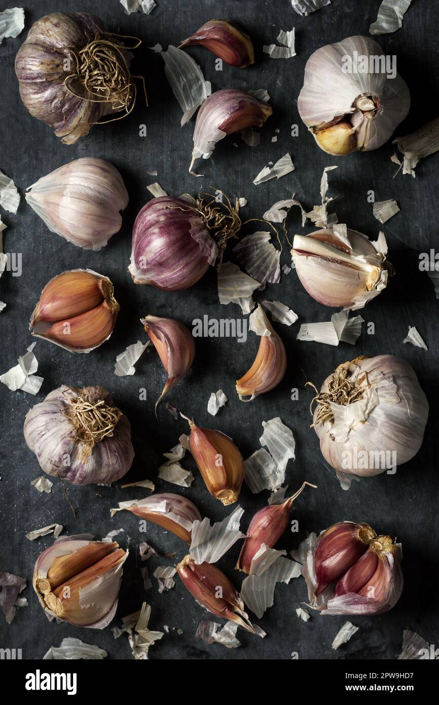 Fresh garlic bulbs and cloves grouped on black background. Flat lay ...