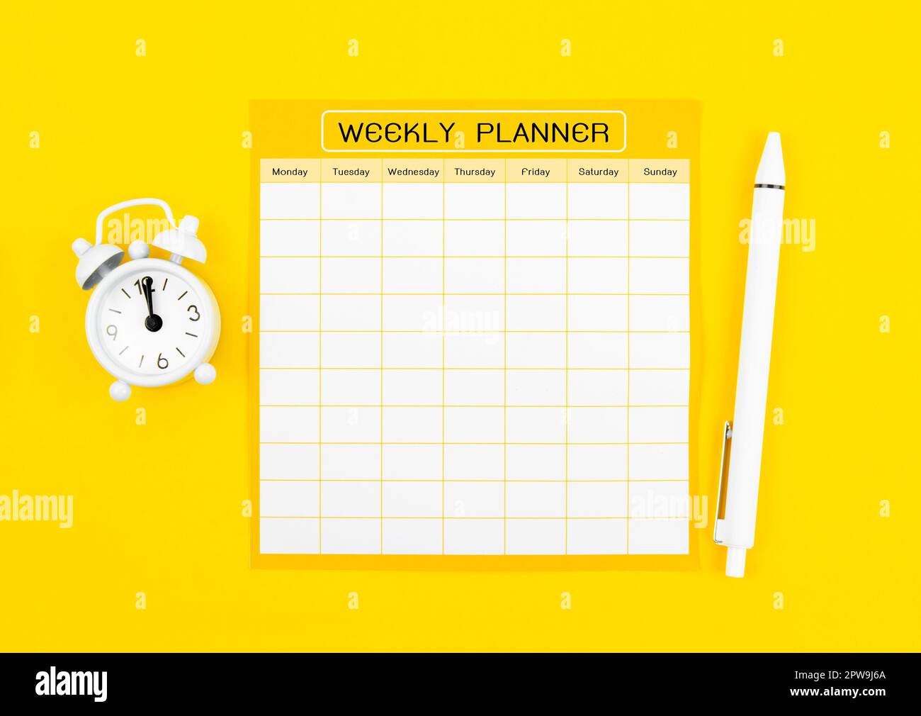 Blank weekly plan notice block with alarm clock with yellow background