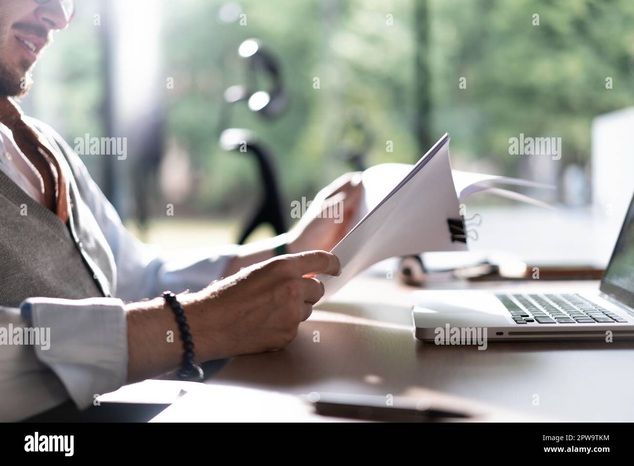 Businessman hands holding pen for working with stack of paper files, searching information, business report papers and piles of unfinished documents i Stock Photo