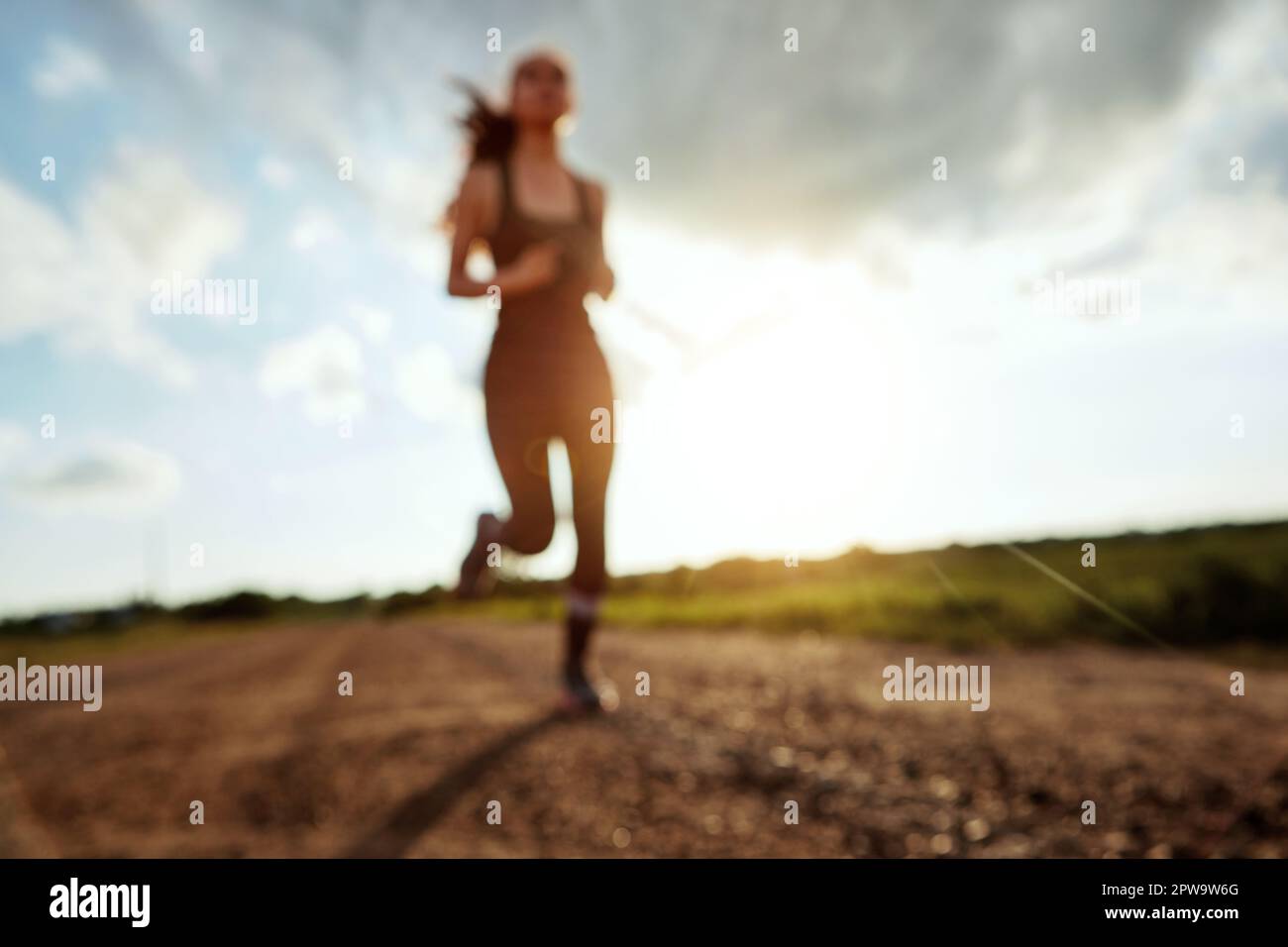 When your legs get tired, run with your heart. a fit young woman out for a run on a beautiful day. Stock Photo