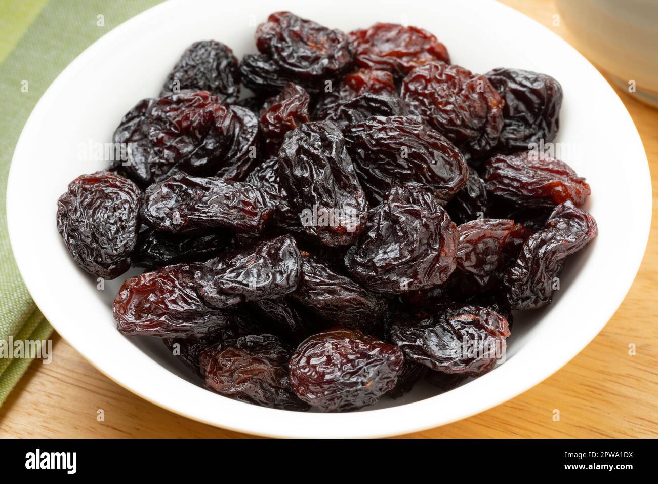 White bowl with large black flame raisins from Chile close up Stock Photo