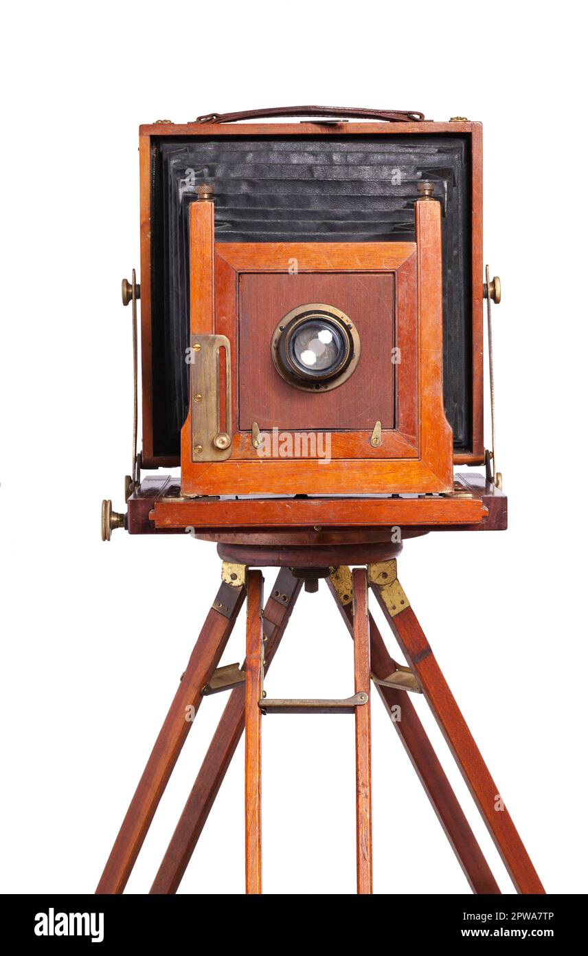 Antique bellows style camera front view close up on an old wooden tripod isolated on white Stock Photo