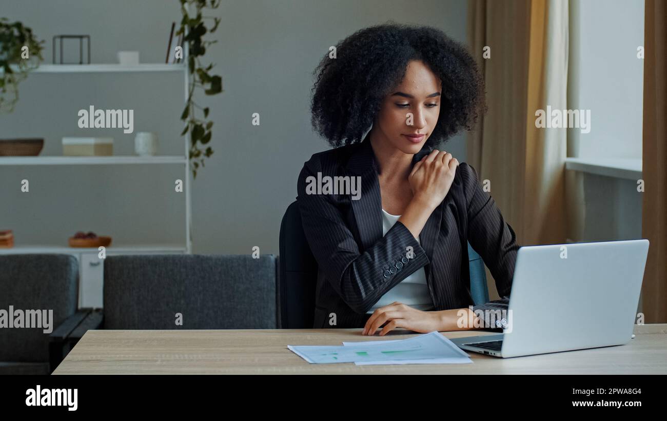 Young ethnic african american woman employee work overtime on computer