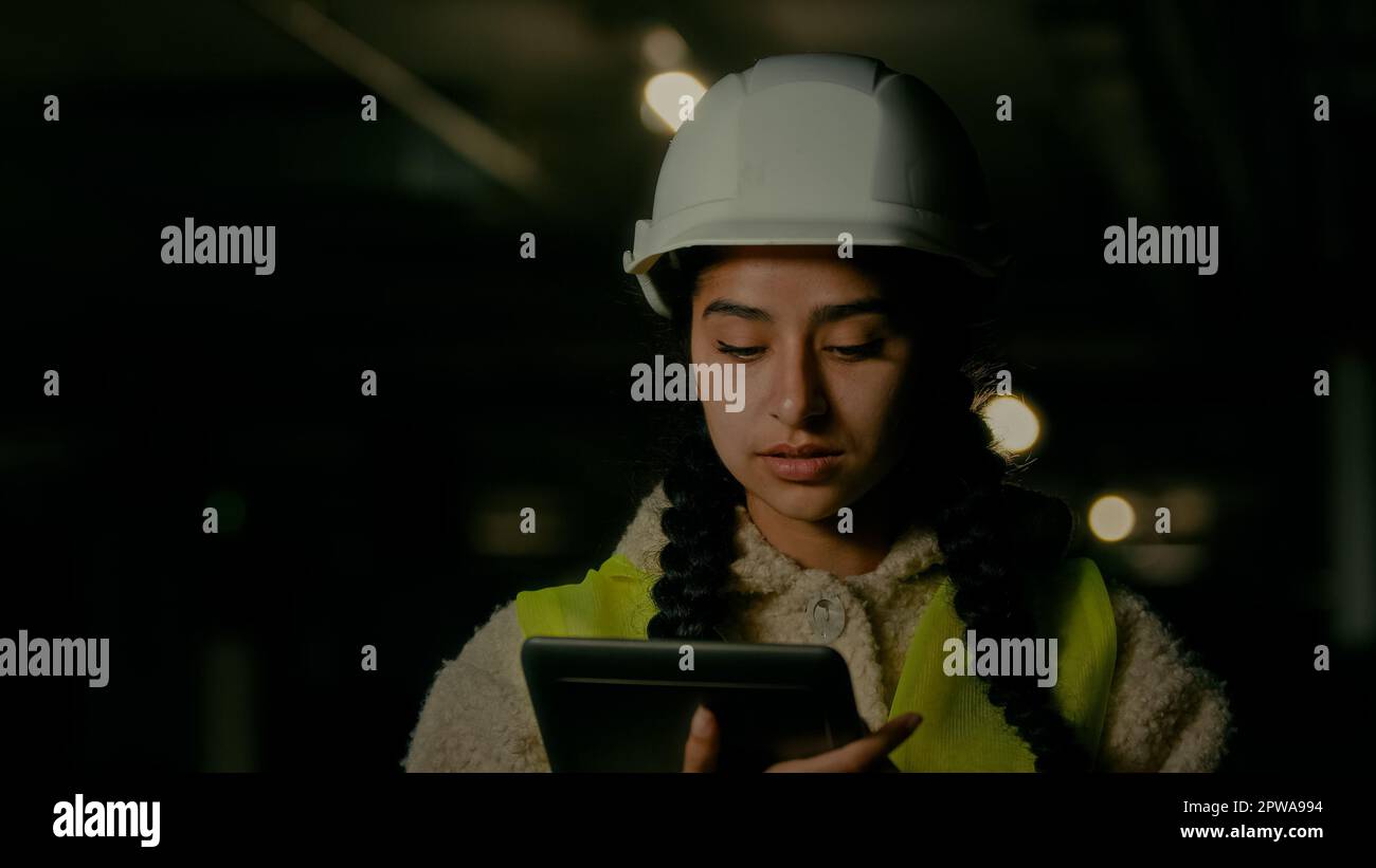 Arabian woman industrial engineer supervisor designer architect in uniform think about new project make notes on electronic tablet young female Stock Photo