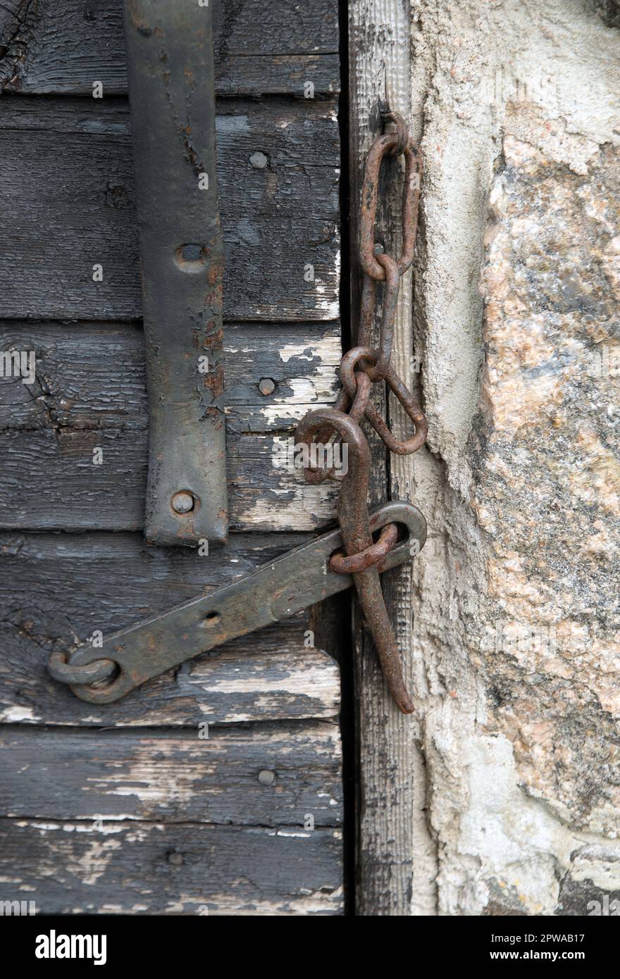 Old hook on closed door Stock Photo