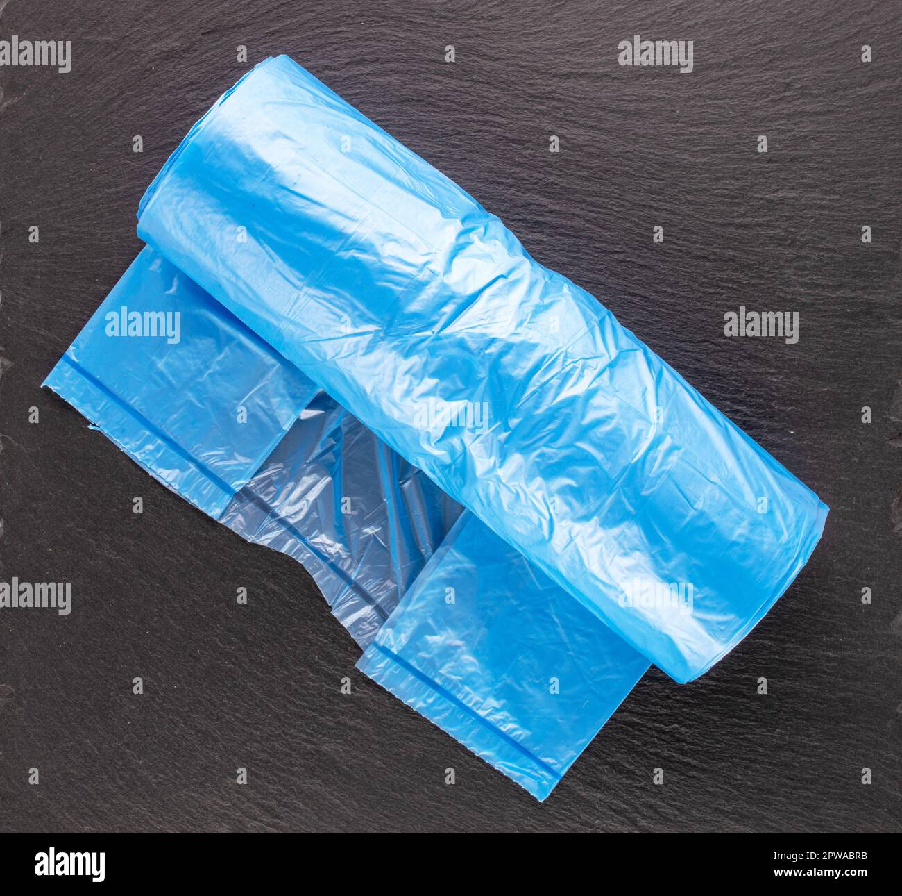 One pack of plastic garbage bags on slate stone, macro, top view Stock