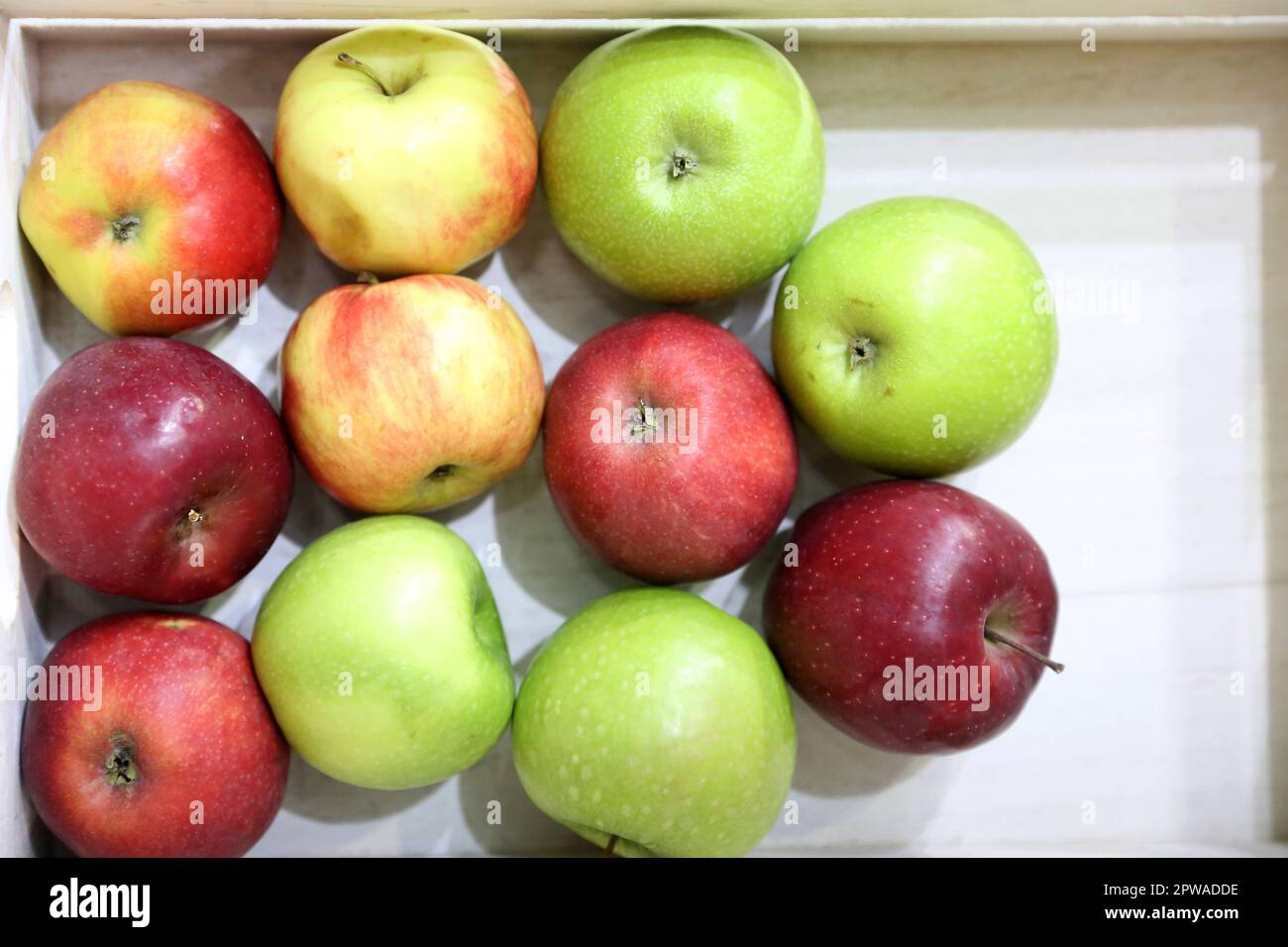 Pile of various apples background in box. Grocery store. Natural fruits