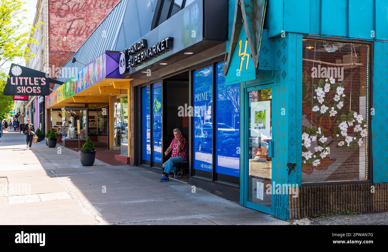 A man playing violin in a storefront entranceway on Forbes Avenue in