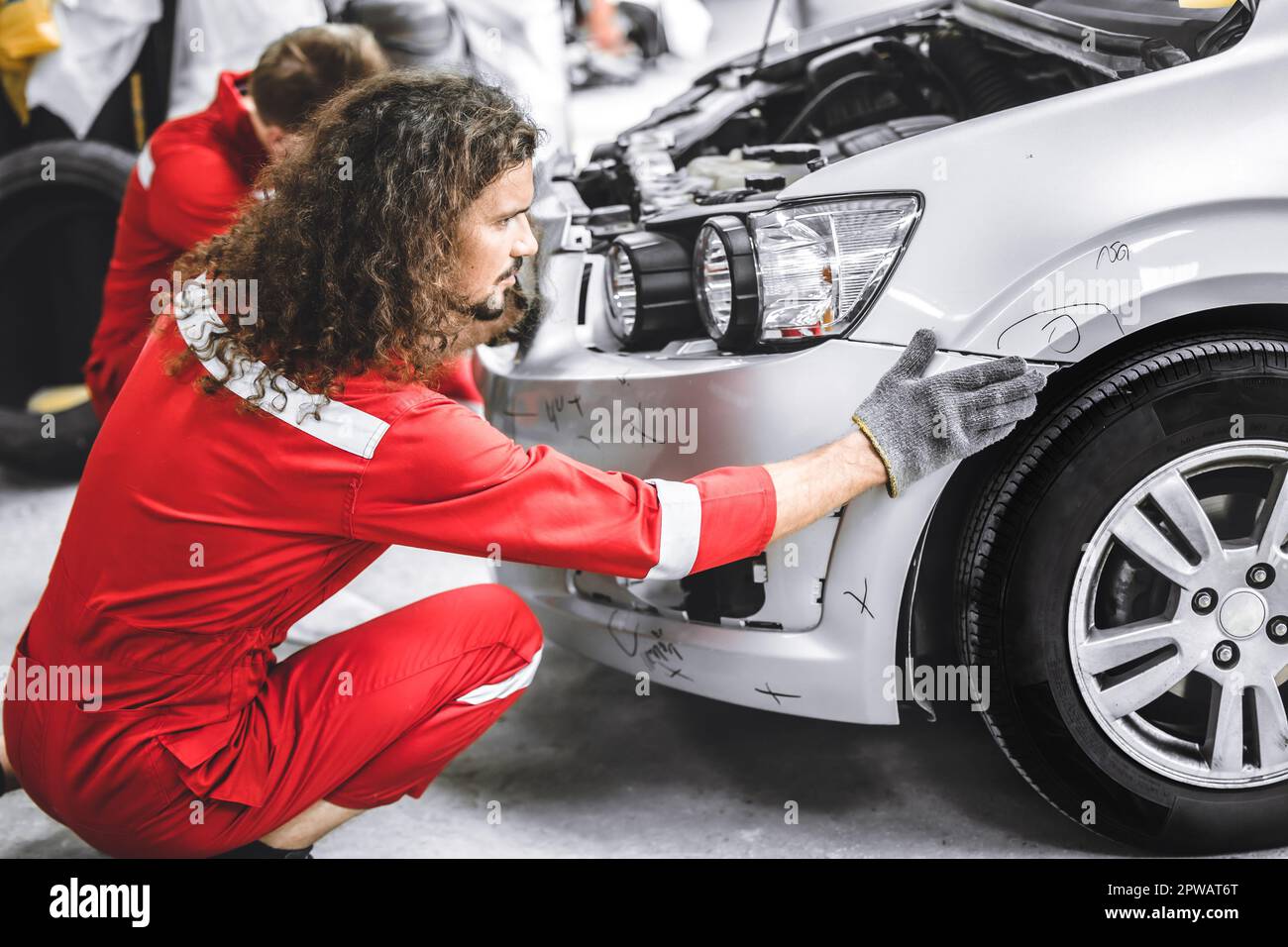Mechanic garage auto workshop team working service repair fix damaged front bumper accident car Stock Photo